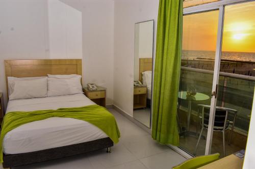 a bedroom with a bed and a view of the ocean at Hotel Isla Capri in Cartagena de Indias