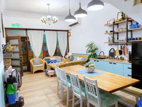 a kitchen and living room with a wooden table and chairs at 墾丁Pig House 豬窩親子包棟 in Hengchun
