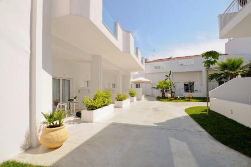 a courtyard of a white building with potted plants at Lefko Suites in Hanioti
