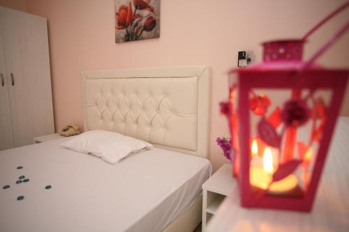 a bedroom with a white bed with a white headboard at Sun Hotel in Polykhrono