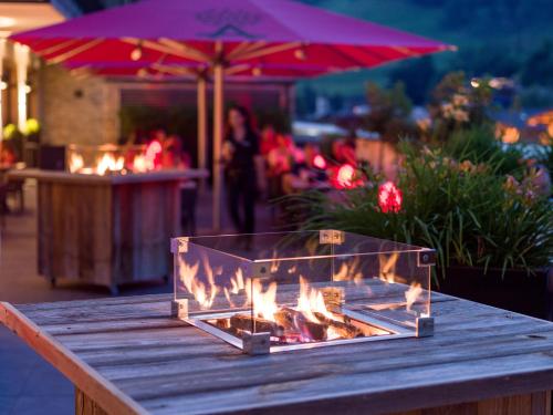 a wooden table with a fireplace on top of it at Hotel Adapura Wagrain in Wagrain