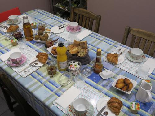 a table with a blue and white table cloth with food at Chambres du Petit Bois in Charleville-Mézières
