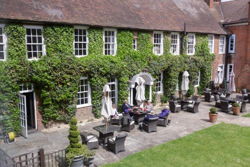a group of people sitting at a table in front of a building at Bush Hotel Farnham in Farnham