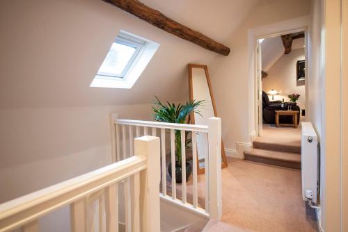 a stairwell with a skylight and a staircase with a stair case at Neroli River View Apartment in Bourton on the Water
