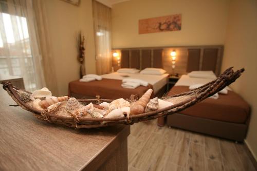 a room with two beds and a basket on a counter at Sun Hotel in Polykhrono