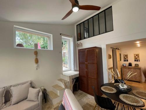 een woonkamer met een bank en een tafel bij Jolie annexe du mas dans le cœur de la garrigue nîmoise in Nîmes