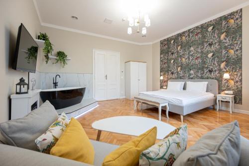 - un salon avec un lit et un canapé dans l'établissement Central Park Rooms, à Oradea