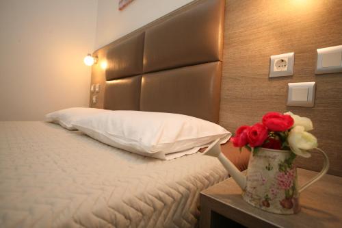 a hotel room with a bed with a vase of flowers at Sun Hotel in Polykhrono