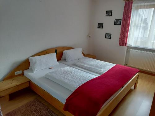 シュトゥーベン・アム・アールベルクにあるPfarrhofのベッドルーム1室(木製ベッド1台、赤い毛布付)
