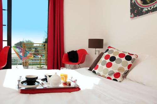 a bed with a tray with a breakfast on it at Les Canisses in Saint-Pierre-la-Garenne