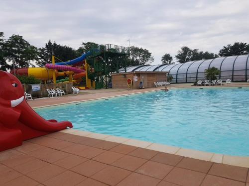 een zwembad met een waterpark met een glijbaan bij Cottage sword beach in Hermanville-sur-Mer