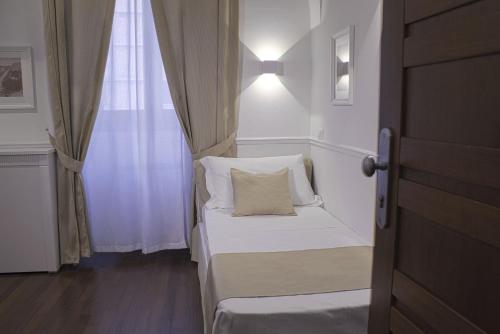 a small bedroom with a white bed and a window at Palazzo Sant'Elena in Foggia
