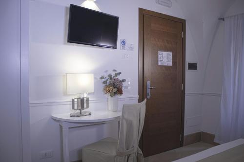 a room with a table and a television on a wall at Palazzo Sant'Elena in Foggia