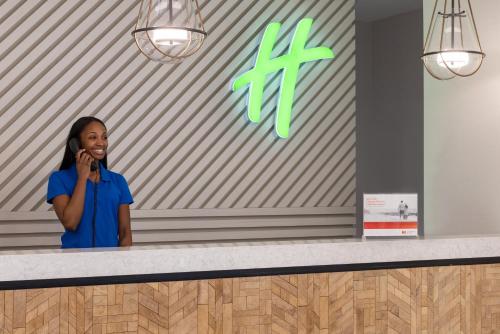 a woman talking on a cell phone in front of a wall at Holiday Inn & Suites Ocean City by IHG in Ocean City