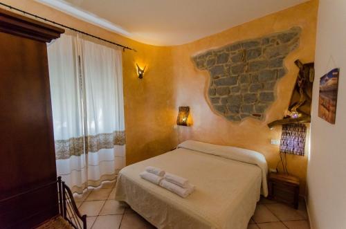 a bedroom with a bed with towels on it at La Pavoncella in Tortolì