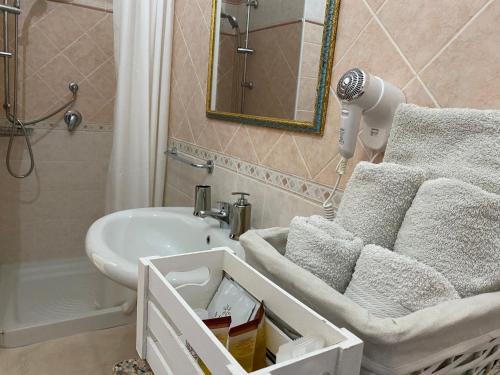 a bathroom with a sink and a bath tub with towels at Villa Bianca in Tertenìa
