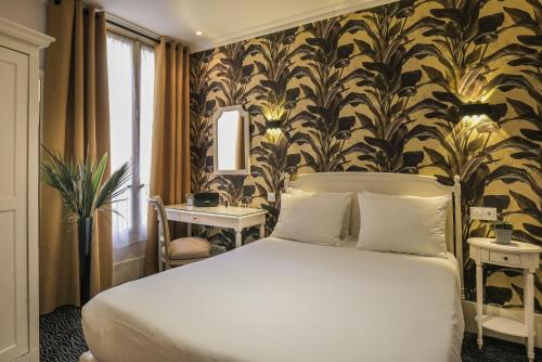 a bedroom with a white bed and a wall with a wallpaper at Hotel London in Paris