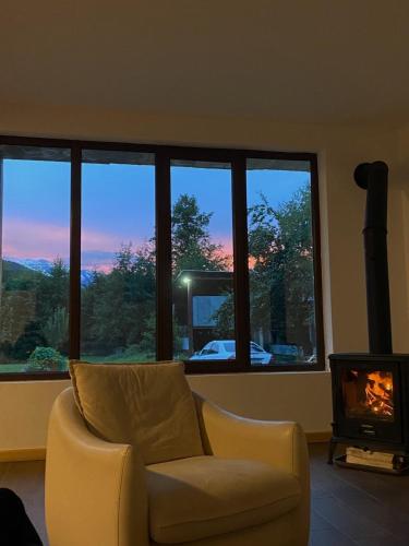 a living room with a chair and a fireplace and a television at Beko’s garden Inn in Mestia