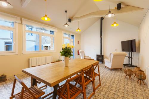 uma sala de jantar com uma mesa de madeira e cadeiras em Hotel Casa da Galbana em Friol