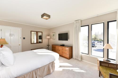 a bedroom with a bed and a tv and windows at 305 Northgate at Silverado in Napa condo in Napa