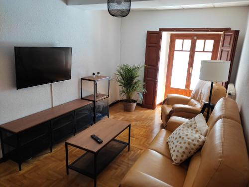 een woonkamer met een bank en een flatscreen-tv bij Casa del Beso II in Luarca