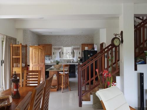 a kitchen and living room with a clock on the wall at SOUTH HILL VILLA in Mahe