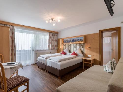 a hotel room with two beds and a couch at das Christophorus in Söll
