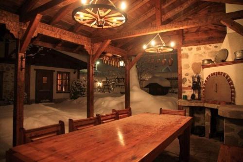 un comedor con una mesa de madera y una habitación con nieve en Chalet White Fang, en Bansko