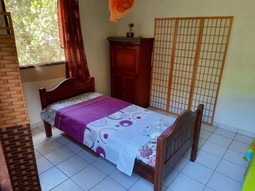 a small bed in a room with a window at Peaceful House in Vieux-Habitants