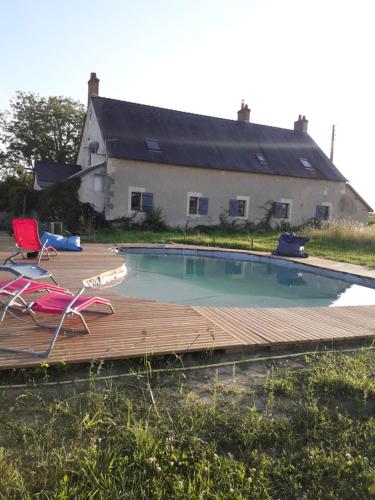 uma piscina com um deque de madeira e uma casa em Gîte familial La Tabarderie em Courcelles-de-Touraine