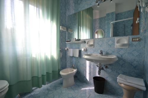 a bathroom with a sink and a toilet at Hotel Boomerang - Check-in & Meals in front at hotel Sporting in Tabiano
