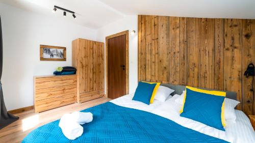 a bedroom with a blue bed with wooden walls at Stacja Sniezka in Karpacz