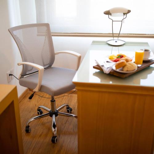 a desk with a chair and a plate of food at Hotel Horizon & Convention Center in Morelia