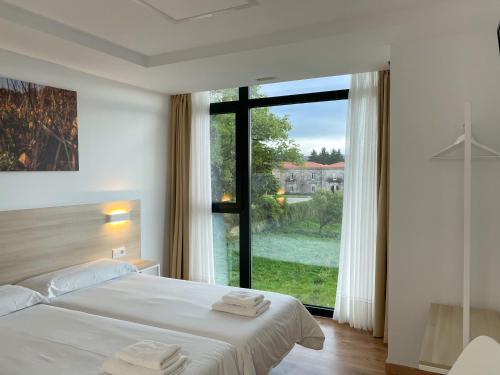 1 dormitorio con cama y ventana grande en Vía Sacra, en Porta