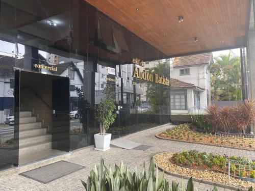 a store front of a building with a sign on it at Ap aconchegante no centro de Joinville com vaga in Joinville