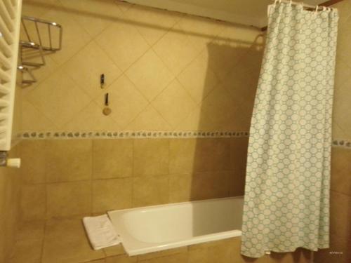 y baño con bañera y cortina de ducha. en CASA BELLO en San Martín de los Andes