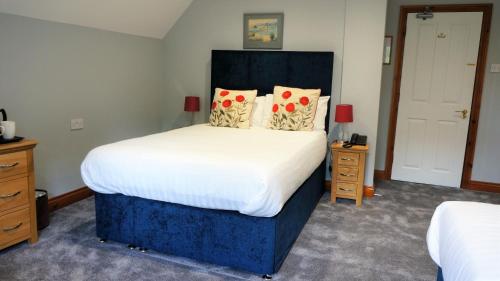 a bedroom with a large bed with white sheets and pillows at The Lawn Guest House Gatwick in Horley