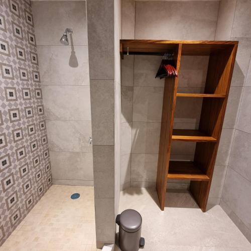 a shower with a wooden shelf in a bathroom at Marboka Hotel & Suites in Puerto Vallarta