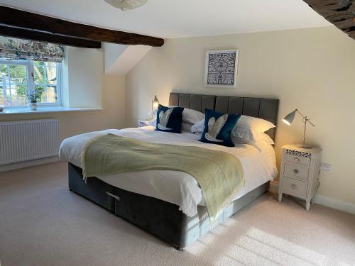 um quarto com uma cama grande e uma janela em The Cosy Nook Cottage Company - Cosy Cottage em Warcop