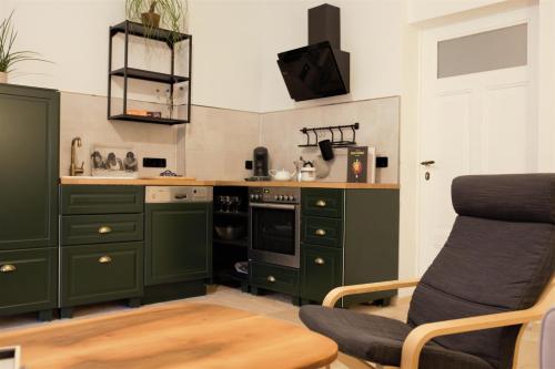 a kitchen with green cabinets and a chair in it at Magnolia Suite in Eisenach