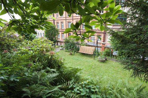 a garden with a bench in front of a building at Magnolia Suite in Eisenach