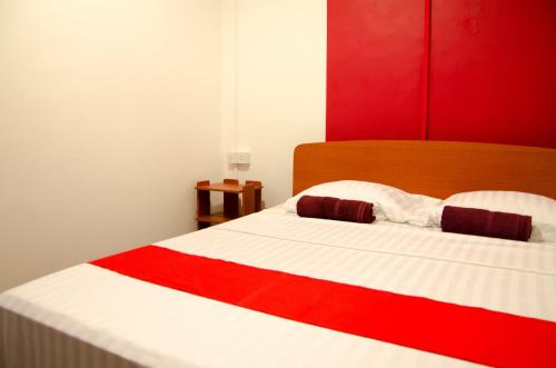 a red and white bed with a red and white blanket at Backpack Lanka in Colombo