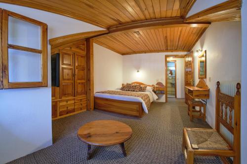 a bedroom with a bed and a wooden ceiling at Hotel Victoria in Metsovo