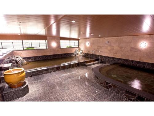 ein großes Bad mit einer großen Badewanne in der Mitte in der Unterkunft Yaoji Hakata Hotel - Vacation STAY 59136v in Fukuoka