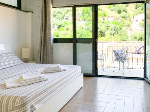 um quarto com 2 camas e vista para uma varanda em Giardini Beach loft em Giardini Naxos