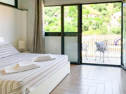 a bedroom with two beds and a view of a balcony at Giardini Beach loft in Giardini Naxos