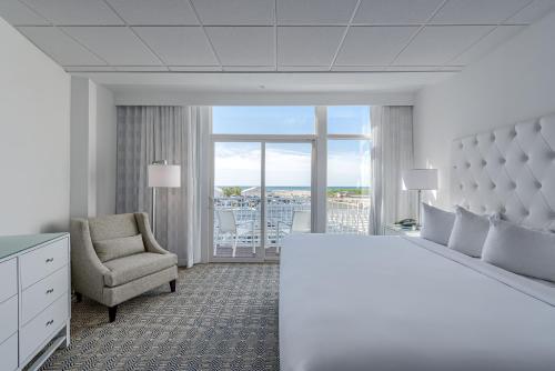 ワイルドウッド・クレストにあるICONA Diamond Beachのベッドルーム(大きな白いベッド1台、椅子付)