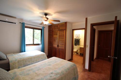 a bedroom with two beds and a ceiling fan at Villa Serenidad in Paquera
