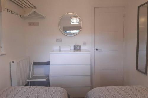 a bedroom with a mirror and a sink and a chair at Chalet 174 Glan Gwna Park Caernarfon in Caeathro