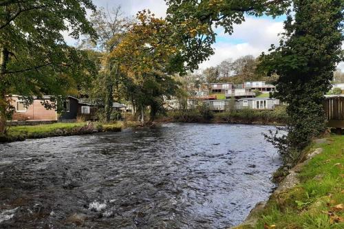 a river in a town with houses and trees at Chalet 174 Glan Gwna Park Caernarfon in Caeathro